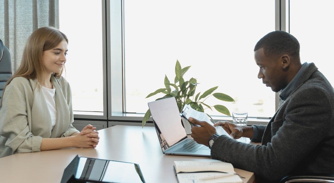 Man at corporate business desk with woman on other side