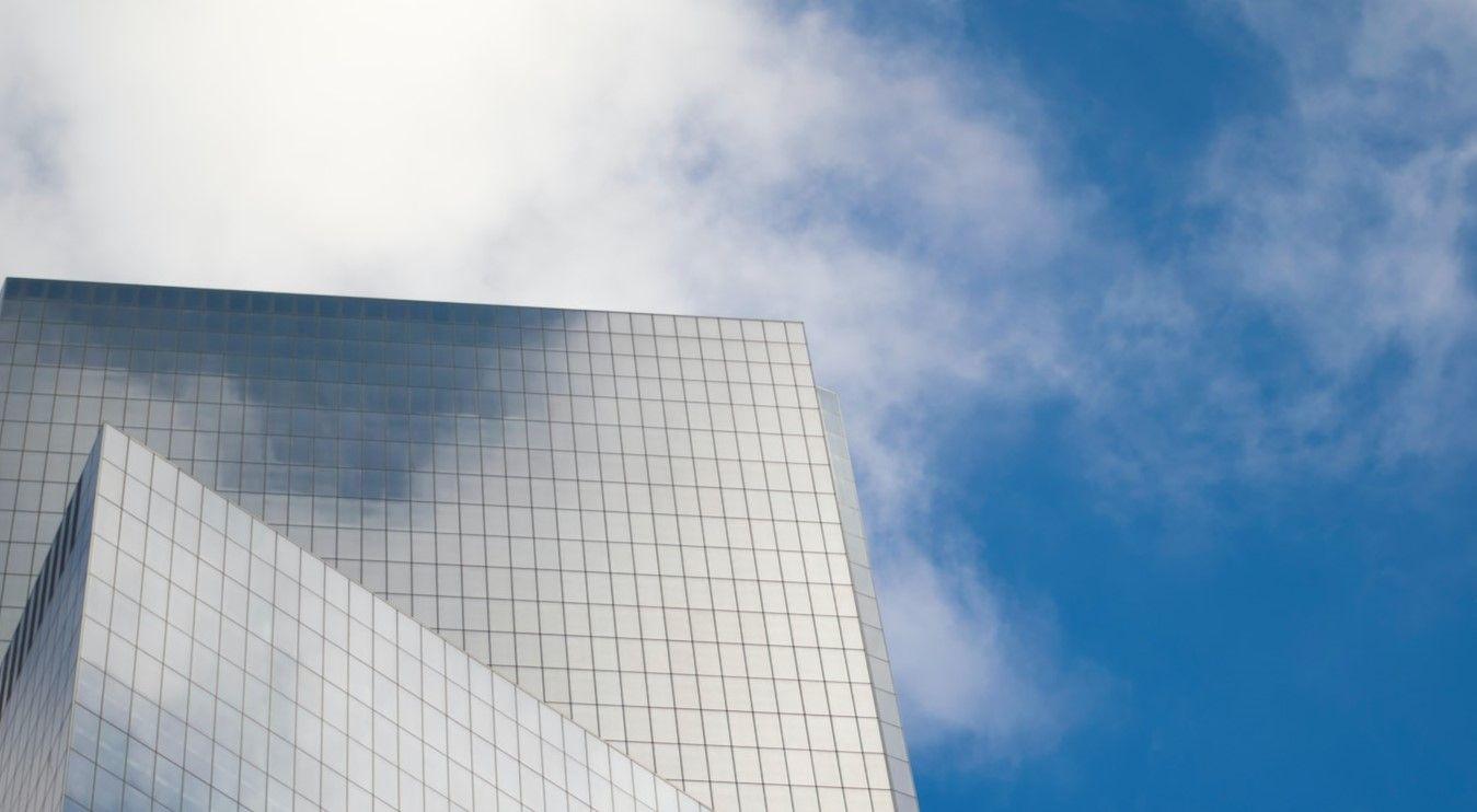 Reflective building with clouds in sky and reflected