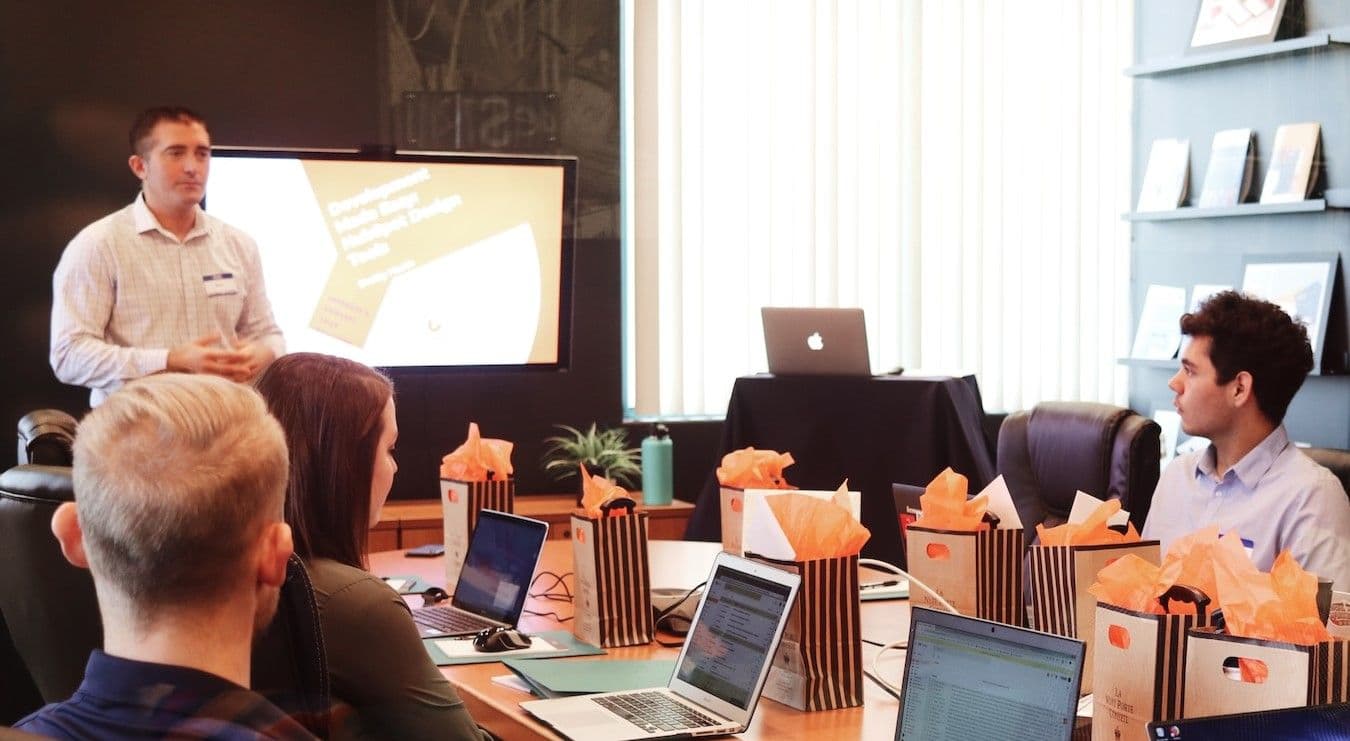 A gathering of individuals seated around a conference table in a meeting space.